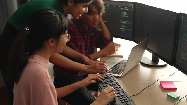 Slow motion back end software developer engineer for computer programming working together on debugging writing computing code, solving complex algorithms display on monitor in office. Burgeoning
