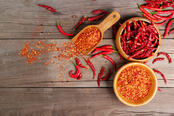 Dried chilies with chili powder, pepper, and red paprika in a wooden bowl Spicy seasoning Healthy...