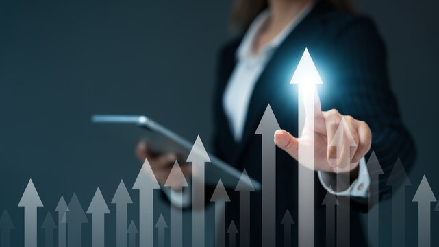 Businesswomen touch arrow graph analyzing company growth, future business growth, development to achieve goals, business outlook, and financial data for long-term investment..