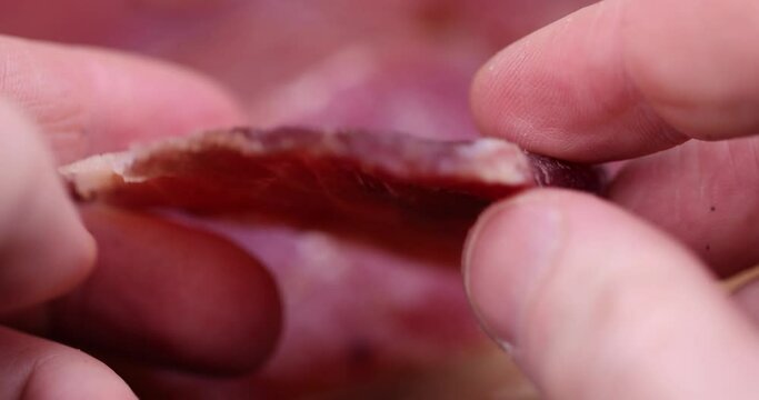 dried meat on paper in close-up, pieces of dried pork with spices and salt on crumpled paper