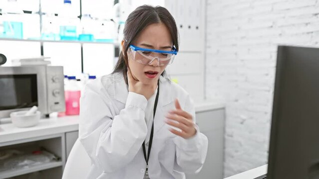 Young chinese woman scientist in lab struggles with painful health problem, suffocating and strangling at the hands of invisible asthma