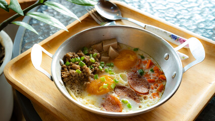 fried egg with sausage and pork meat topping