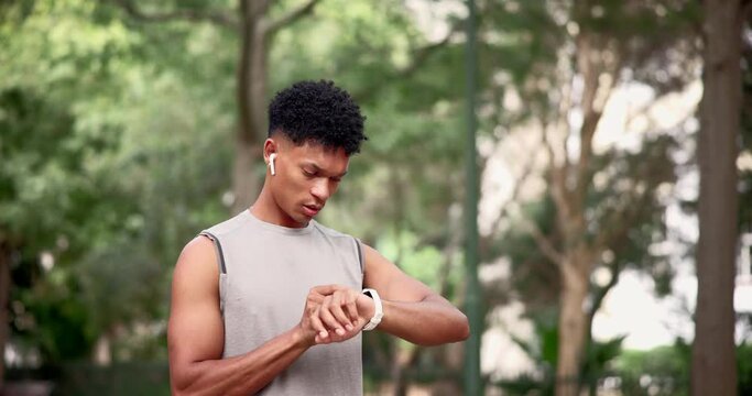 Man, fitness and running with watch for checking time, monitoring or performance at nature park. Active male person or runner looking at wristwatch to track heart rate for workout or outdoor exercise