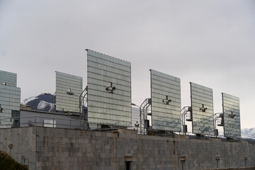 The grandeur of snow-capped mountains is mirrored in the sleek surfaces of a solar panel array, a...