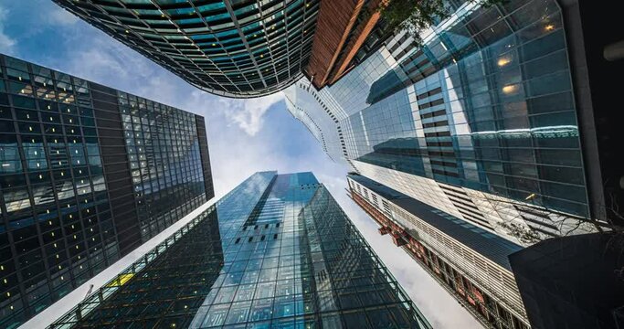 4K Footage Time lapse Low angle of tall corporate buildings skyscraper with reflection of clouds among high buildings and glass elevator in building center in London, England, United Kingdom