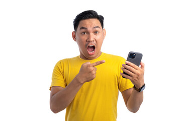 Excited handsome Asian man pointing finger at mobile phone with surprised facial expression isolated on white background