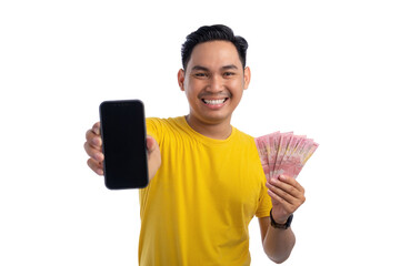 Happy handsome Asian man holding mobile phone with blank screen and money isolated on white background