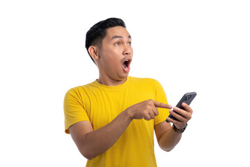 Surprised young Asian man using smartphone and looking aside at copy space isolated on white background