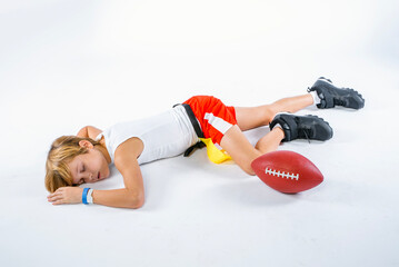 Young male flag football player lying injured on the ground unconscious