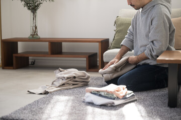 洗濯を畳む家事をする男性の顔無し　コピースペースあり © kapinon