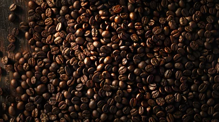 Tuinposter Top view of the background. Roasted coffee beans with a pleasant aroma. Dark brown grains on a wooden background exposed to sunlight. © Alina Tymofieieva
