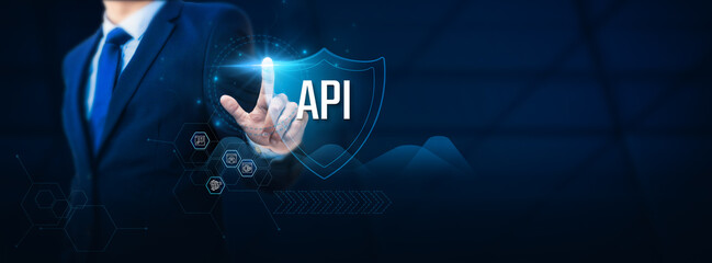 Businessman hand touches an API - APPLICATION PROGRAMMING INTERFACE protection shield. API security concept to safeguard businesses and software systems from accidents and unexpected disasters.
