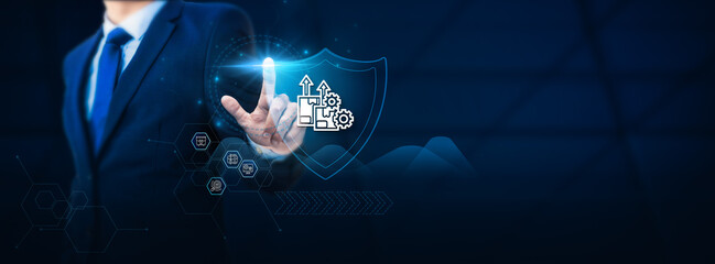 Businessman hand touching a shield symbolizing safety and protection for a development project....