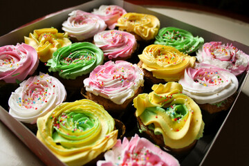 Delicious homemade cup cake with colorful cream on top and sprinkles.