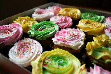 Homemade birthday cup cakes with butter cream topping and colorful sprinkles.