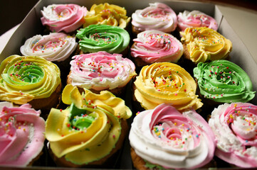 Homemade birthday cup cakes with butter cream topping and colorful sprinkles.