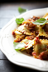 Ravioli with mushrooms and fresh basil. Dark wooden background. Close up	