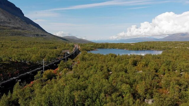 Aerial: ore train by a lake in northern Sweden. Ofotbanen. Ofoten line