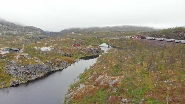 Aerial: Swedish passenger train in northern Norway close to S&oslash;sterbekk station by a lake