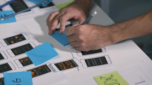An employee is planning an event in a conference room with documents scattered across the table before preparing to present it in front of his co-workers and boss.