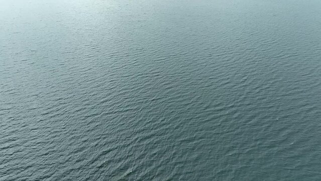 The motion of water rippling across serene Lake Toba. Aerial, reveal