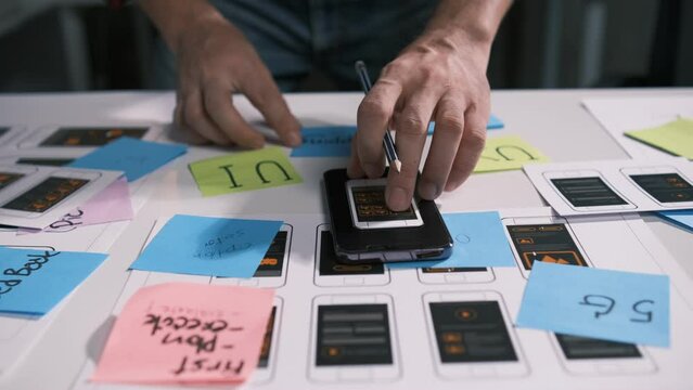 An employee is planning an event in a conference room with documents scattered across the table before preparing to present it in front of his co-workers and boss.