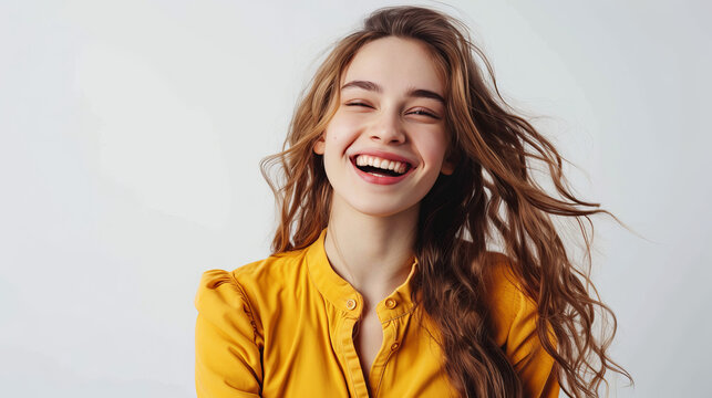 The image showcases a young woman in a yellow blouse, her joy expressed through her laughing pose