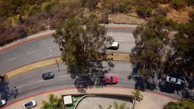 Overhead View Of Cars Driving Through Curved Road. - aerial shot