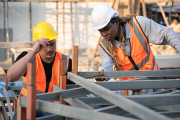 Worker engineer African woman working with caucasian worker at construction site	 - 758590812