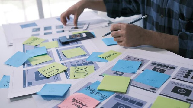 An employee is planning an event in a conference room with documents scattered across the table before preparing to present it in front of his co-workers and boss.