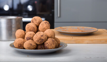 A plate of homemade chocolate truffles on the background of a modern kitchen