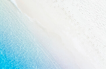 The soft wave water of the sea on the sandy beach background
