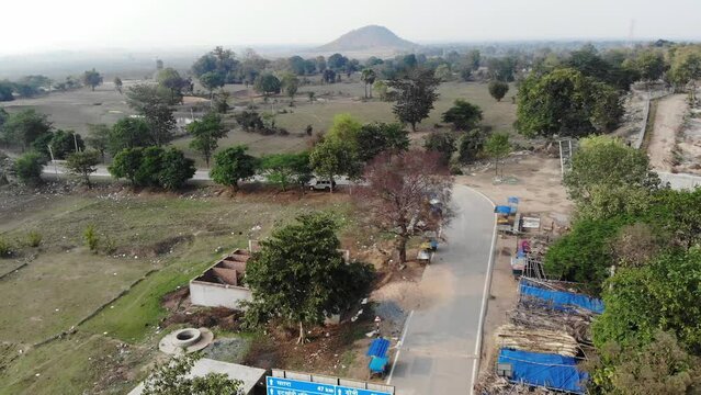 Aerial shot of a village in Jharkhand with asphalt road and green vegetations and mountain in India. Jharkhand tourism.
