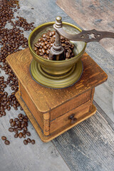 Vintage coffee grinder on a textured table, coffee bonnets - vertical