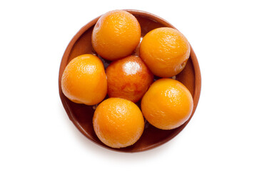 Yellow canned plums on a plate. Plate with plums on white background.