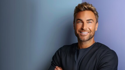 Fototapeta premium A man with a beard and a smile is standing in front of a blue wall