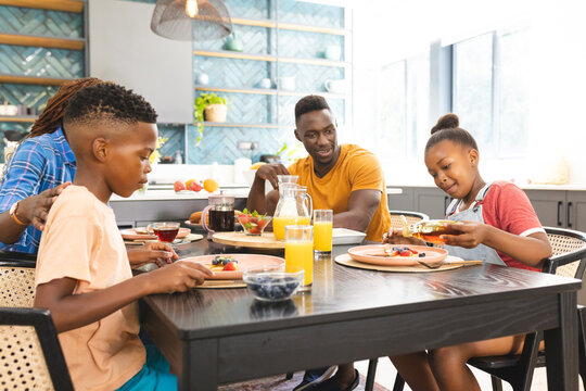 An African American family enjoys a breakfast together at home, diverse group