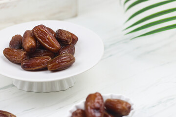 Kurma or Dates fruit on marble white background. Breakfasting concept in Ramadan month. Islamic template for text background.