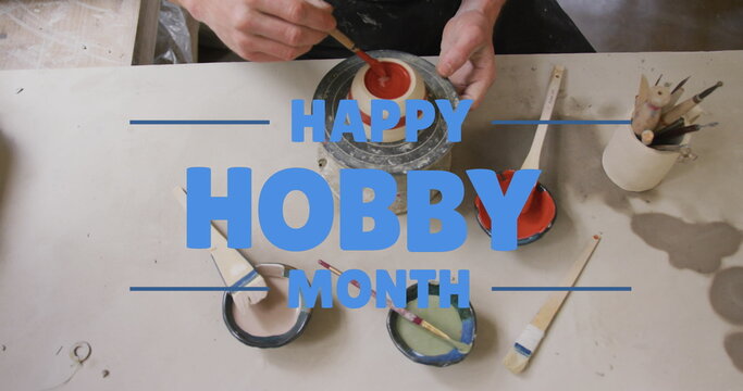 Image of happy hobby month text over caucasian man painting pottery