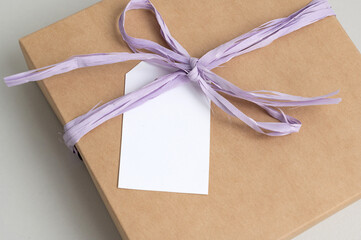 Mockup of a tag on a brown craft box with a ribbon. Space for text, copy space