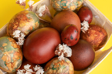 Obraz na płótnie Canvas Assortment of Easter eggs with natural leaf patterns in a wooden basket