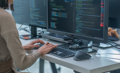 close up hand of Asian prompt engineer developer coding app with software data sitting in front of...