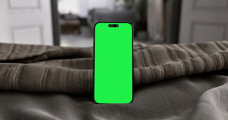 Smartphone place on bed, Green screen of Cellphone, Display mobile phone with mock up, Chroma key...