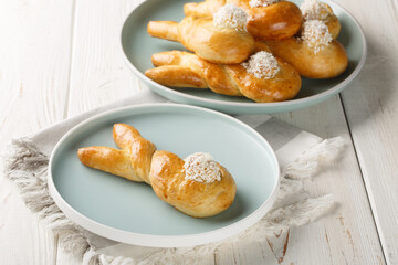 Freshly baked easter bunny made from yeast dough closeup on the plate on the table. Horizontal