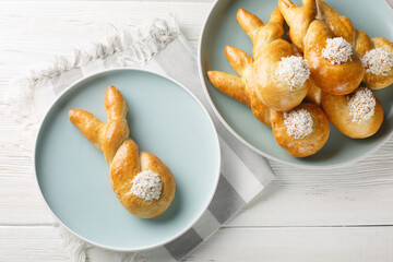 Freshly baked easter bunny made from yeast dough closeup on the plate on the table. Horizontal top...