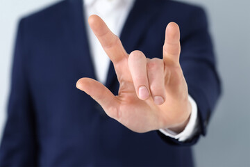 Businessman in blue suit pointing with finger at camera, closeup