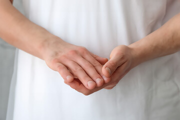 Young pregnant woman holding hands together, closeup. Space for text