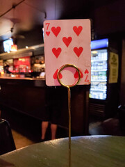 Very interesting idea of waiting at a pub bar table with real cards as for the table number