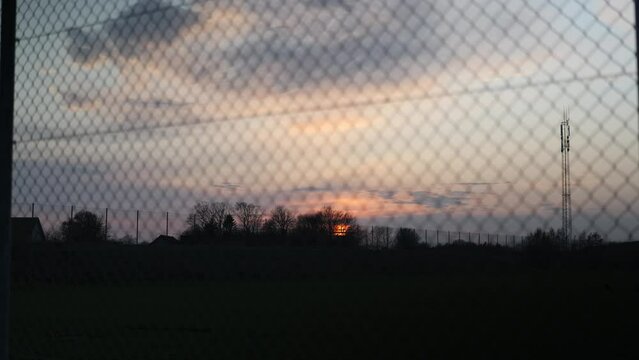 Sunset seen through wire fence