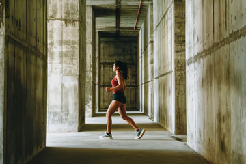 A woman runs through a long, empty hallway